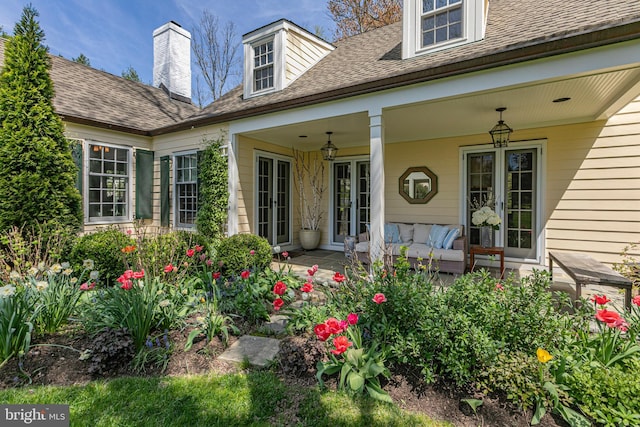 view of exterior entry featuring a shingled roof
