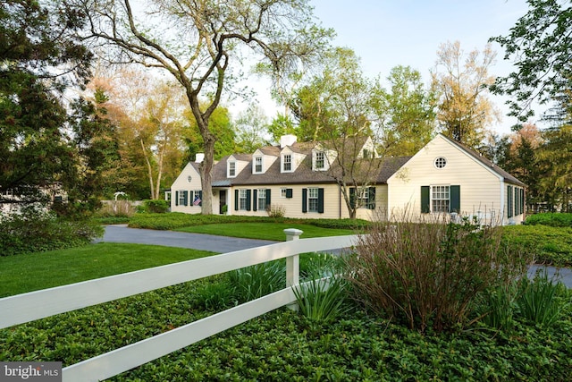 cape cod-style house featuring a front lawn