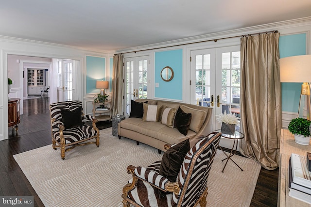 living room featuring a decorative wall, crown molding, wood finished floors, and french doors
