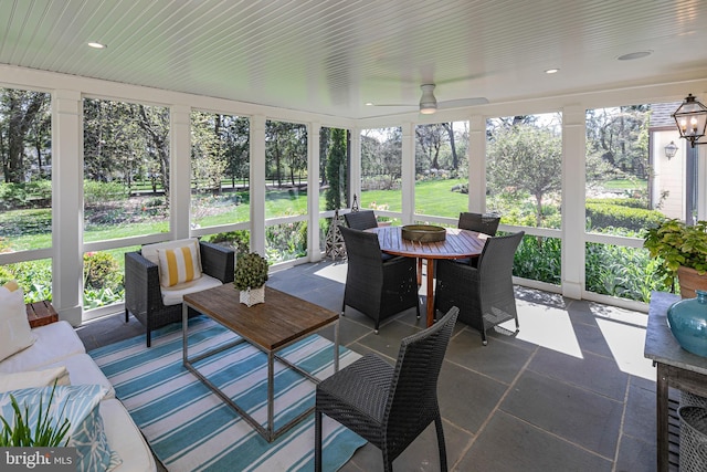 sunroom featuring ceiling fan, outdoor dining space, and plenty of natural light