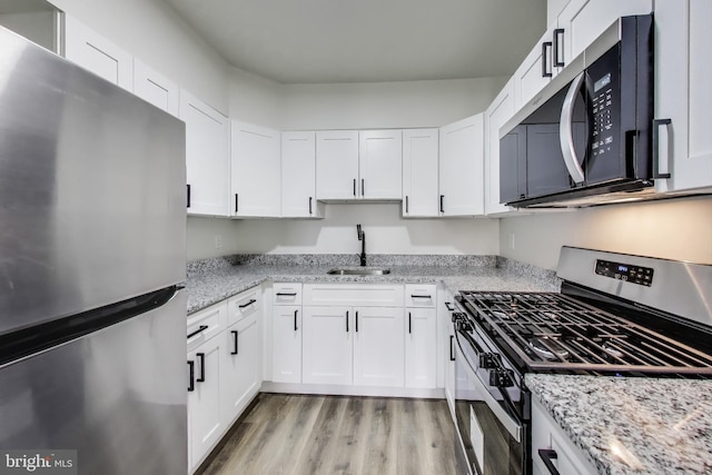 1 Maple Ave, Baltimore, MD 21206 - kitchen featuring stainless steel appliances, a sink, light wood-style flooring, and white cabinetry