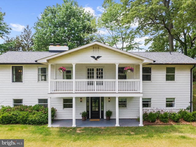 1990 Kate Dr, Port Republic, MD 20676 - back of house featuring a balcony, a chimney, a yard, and a patio area