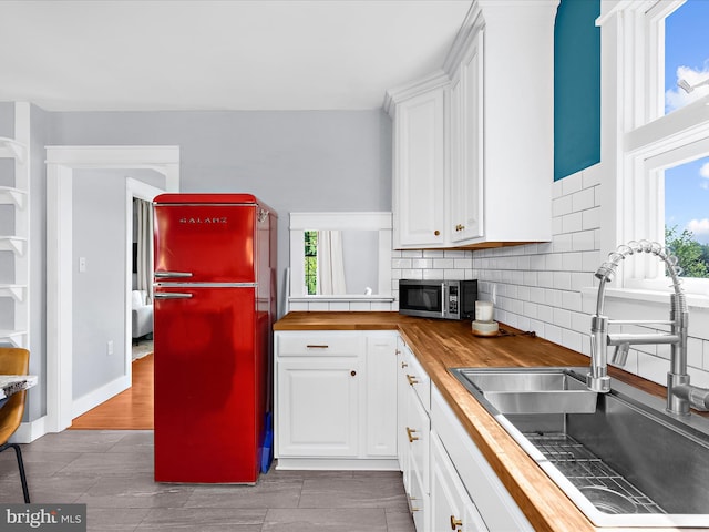1990 Kate Dr, Port Republic, MD 20676 - kitchen featuring a sink, butcher block counters, freestanding refrigerator, stainless steel microwave, and white cabinets