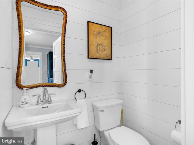1990 Kate Dr, Port Republic, MD 20676 - bathroom featuring a sink, toilet, ornamental molding, and wood walls