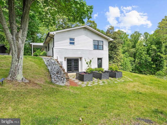 1990 Kate Dr, Port Republic, MD 20676 - rear view of house with french doors, a garden, a lawn, and stucco siding