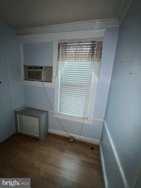 unfurnished dining area with crown molding, baseboards, and wood finished floors