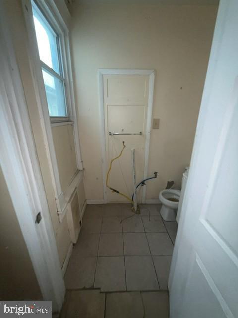 bathroom featuring tile patterned floors, toilet, and baseboards