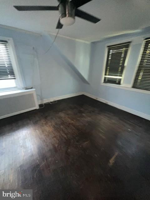 spare room with wood finished floors, baseboards, and ceiling fan