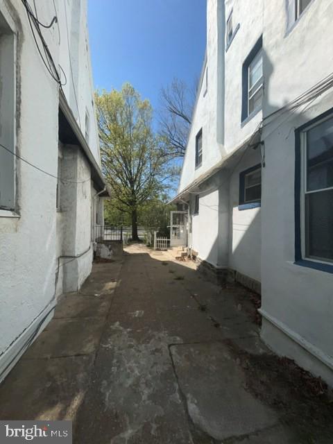 view of side of home with stucco siding and fence