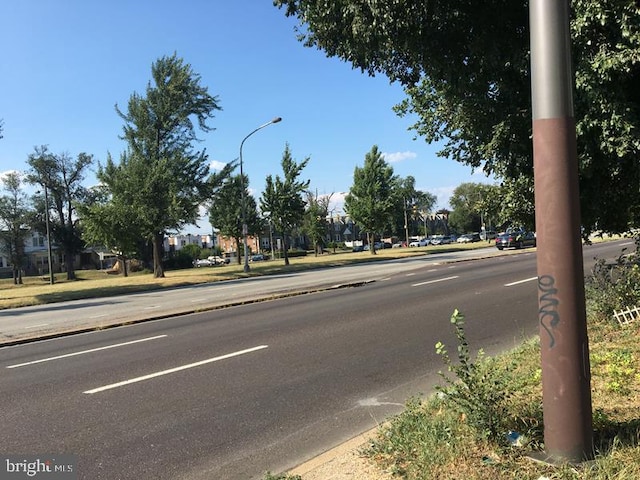 view of street featuring street lights, curbs, and sidewalks