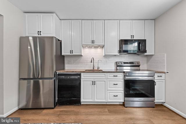 9518 Center St, Vienna, VA 22181 - kitchen with black appliances, a sink, white cabinets, and backsplash