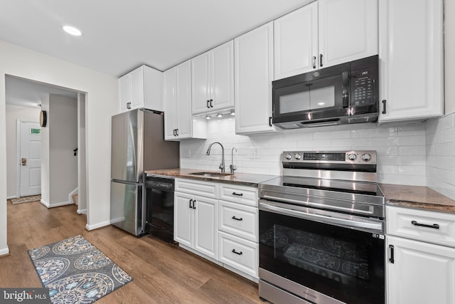 9518 Center St, Vienna, VA 22181 - kitchen with black appliances, a sink, white cabinetry, and recessed lighting