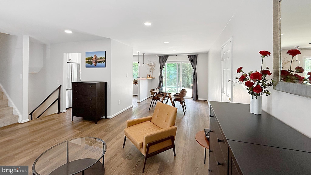 sitting room with stairway, wood finished floors, baseboards, and recessed lighting