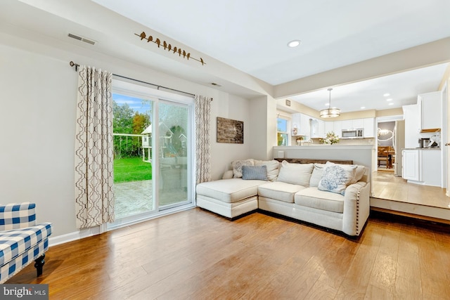 living room with light wood-style floors, recessed lighting, and baseboards