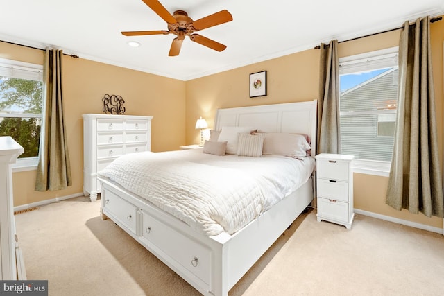 bedroom with light carpet, multiple windows, baseboards, and ornamental molding