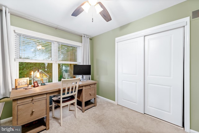office area with ceiling fan, light carpet, and baseboards