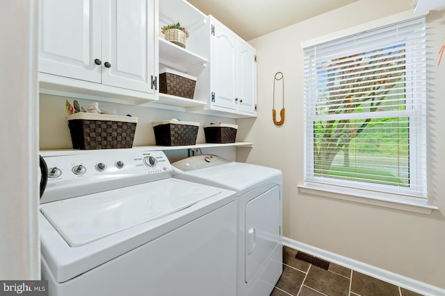 laundry area with washing machine and clothes dryer, cabinet space, baseboards, and dark tile patterned flooring