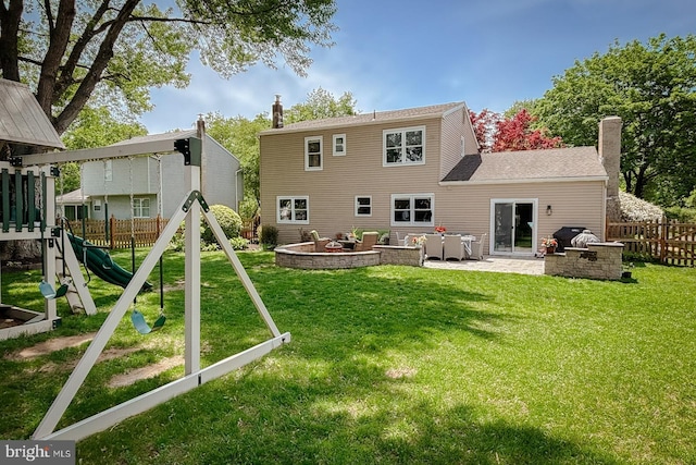 rear view of property with a playground, a patio, and a chimney