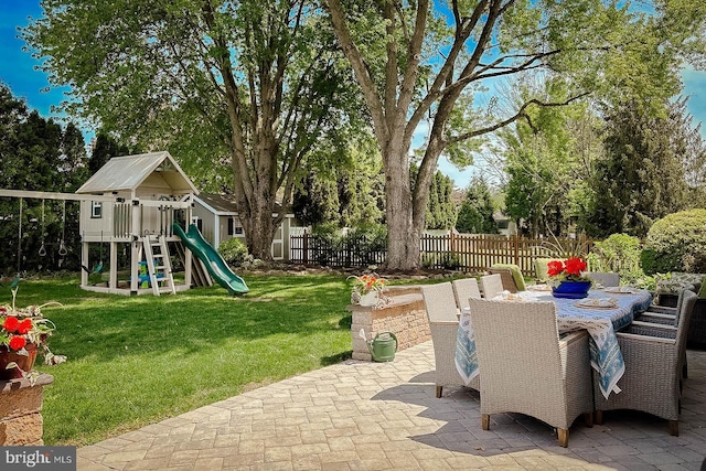 view of patio / terrace featuring a playground and view of wooded area