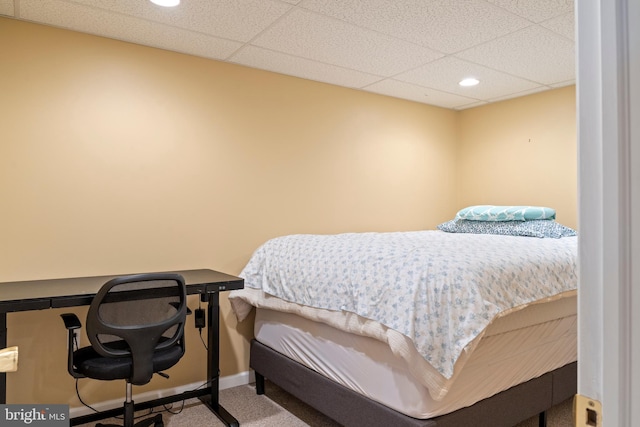 carpeted bedroom with a paneled ceiling, baseboards, and recessed lighting