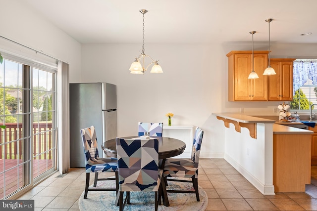 dining room with light tile patterned floors, a chandelier, and baseboards