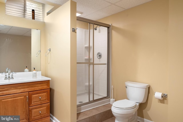 bathroom featuring toilet, a stall shower, tile patterned floors, baseboards, and vanity