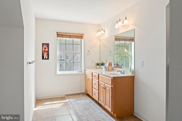 bathroom featuring a sink, double vanity, a healthy amount of sunlight, and tile patterned floors
