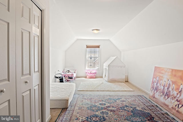 carpeted bedroom featuring vaulted ceiling and baseboards