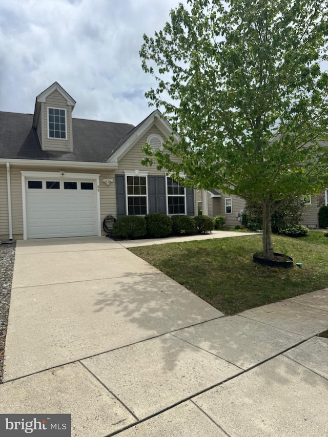view of front of home with a front yard, an attached garage, and driveway