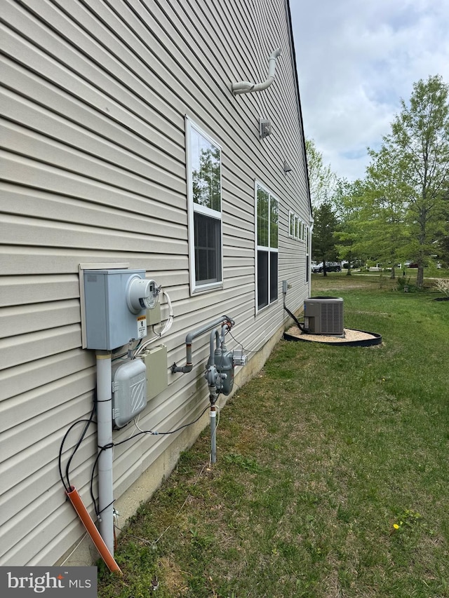 view of side of property featuring a yard and cooling unit