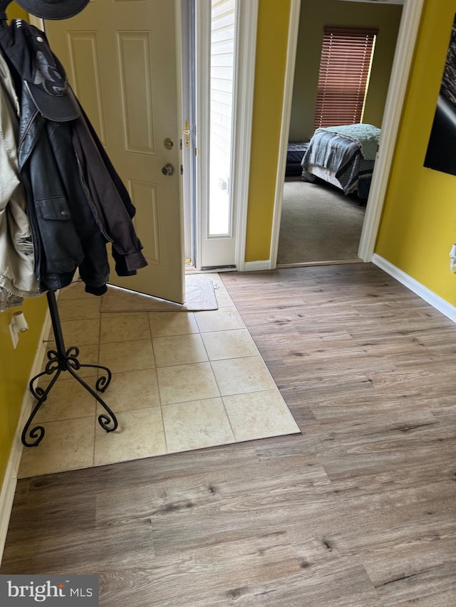 foyer entrance with baseboards and wood finished floors