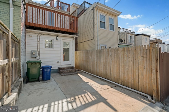 722 S Clinton St, Baltimore, MD 21224 - rear view of house featuring entry steps, a balcony, a fenced backyard, and a patio area