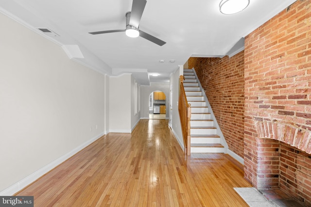 722 S Clinton St, Baltimore, MD 21224 - unfurnished living room with arched walkways, a ceiling fan, light wood finished floors, stairs, and baseboards
