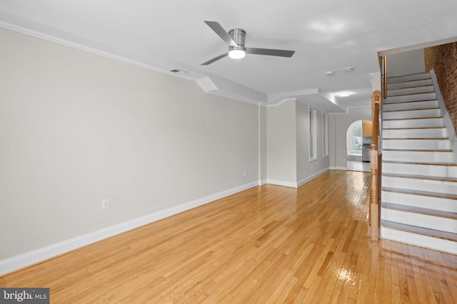 722 S Clinton St, Baltimore, MD 21224 - unfurnished living room with stairway, a ceiling fan, arched walkways, baseboards, and light wood-style floors