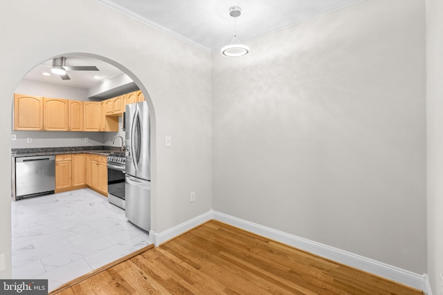 722 S Clinton St, Baltimore, MD 21224 - kitchen with appliances with stainless steel finishes, light brown cabinetry, dark countertops, arched walkways, and a sink
