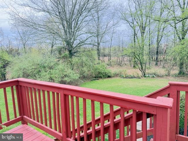 wooden terrace featuring a yard
