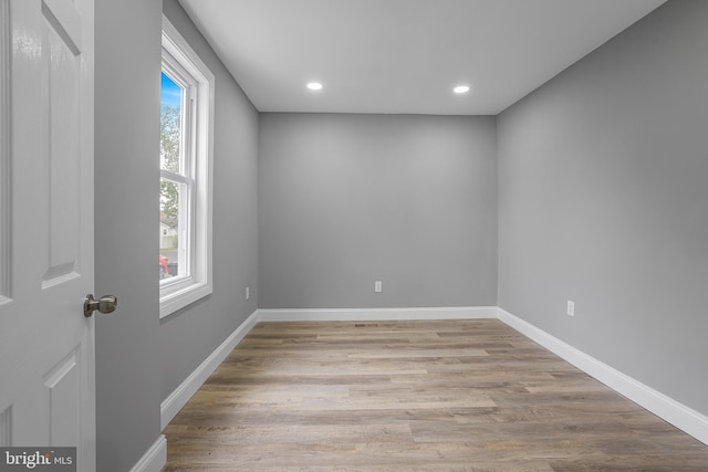 empty room featuring recessed lighting, baseboards, and wood finished floors