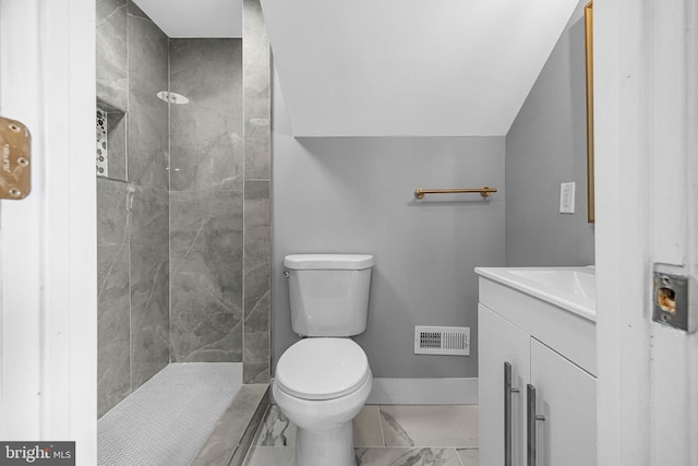 bathroom featuring toilet, a tile shower, visible vents, marble finish floor, and vanity