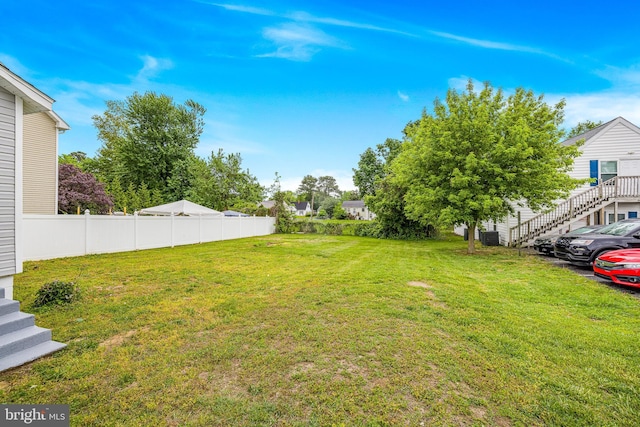 view of yard with fence and stairs