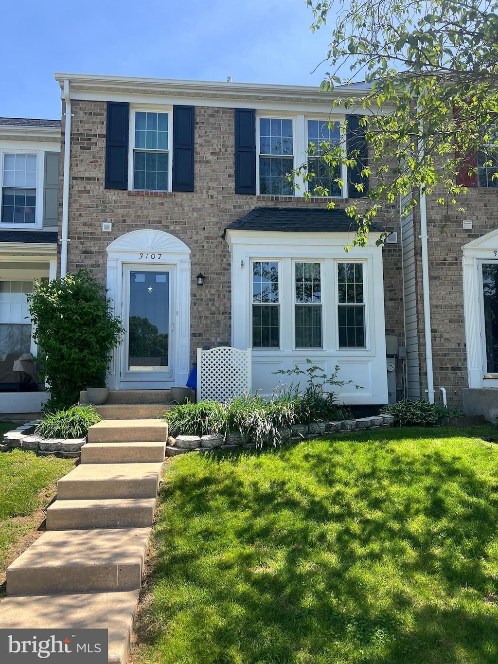view of front of house featuring entry steps, brick siding, and a front yard