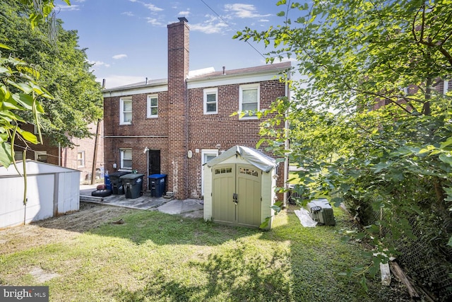 9 47th St SE, Washington, DC 20019 - back of house with a storage unit, a lawn, a chimney, and brick siding