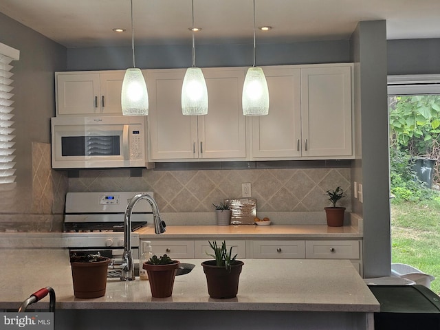 9 47th St SE, Washington, DC 20019 - kitchen featuring white microwave, white cabinetry, and tasteful backsplash