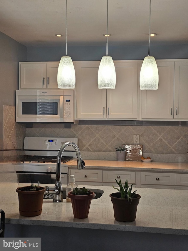 9 47th St SE, Washington, DC 20019 - kitchen featuring white appliances, white cabinets, and backsplash