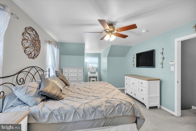 bedroom featuring light carpet, baseboards, lofted ceiling, and ceiling fan