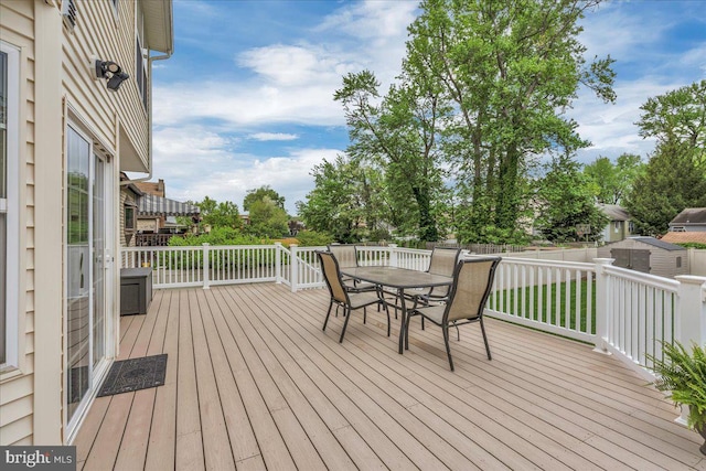 deck with a fenced backyard and outdoor dining area