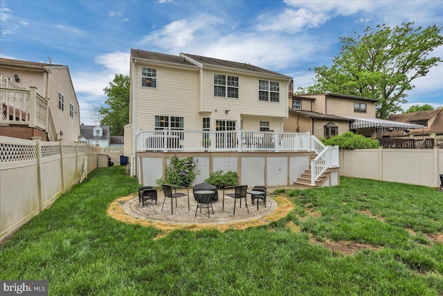 back of property featuring a fenced backyard, a wooden deck, a fire pit, and a yard
