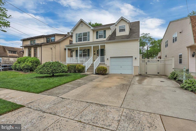 traditional home featuring a gate, a garage, fence, a front lawn, and a porch