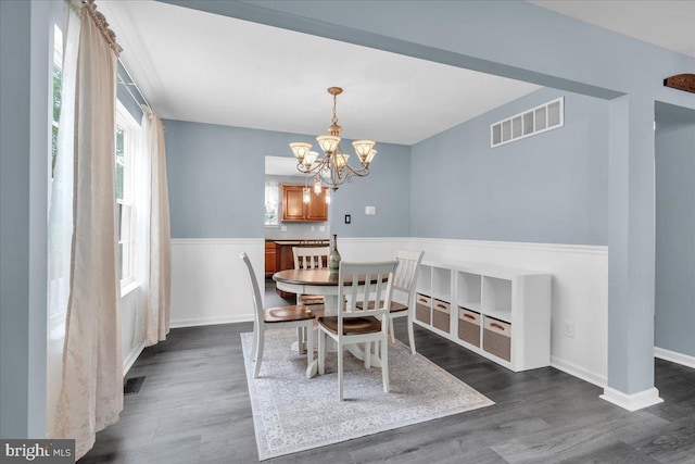 dining space with a chandelier, visible vents, baseboards, and dark wood-type flooring