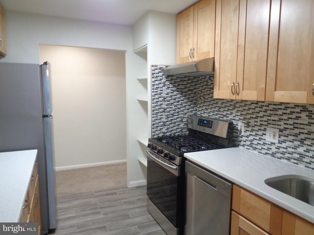 kitchen featuring under cabinet range hood, stainless steel appliances, light brown cabinetry, and decorative backsplash