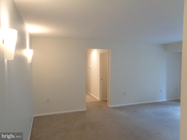 carpeted empty room featuring baseboards